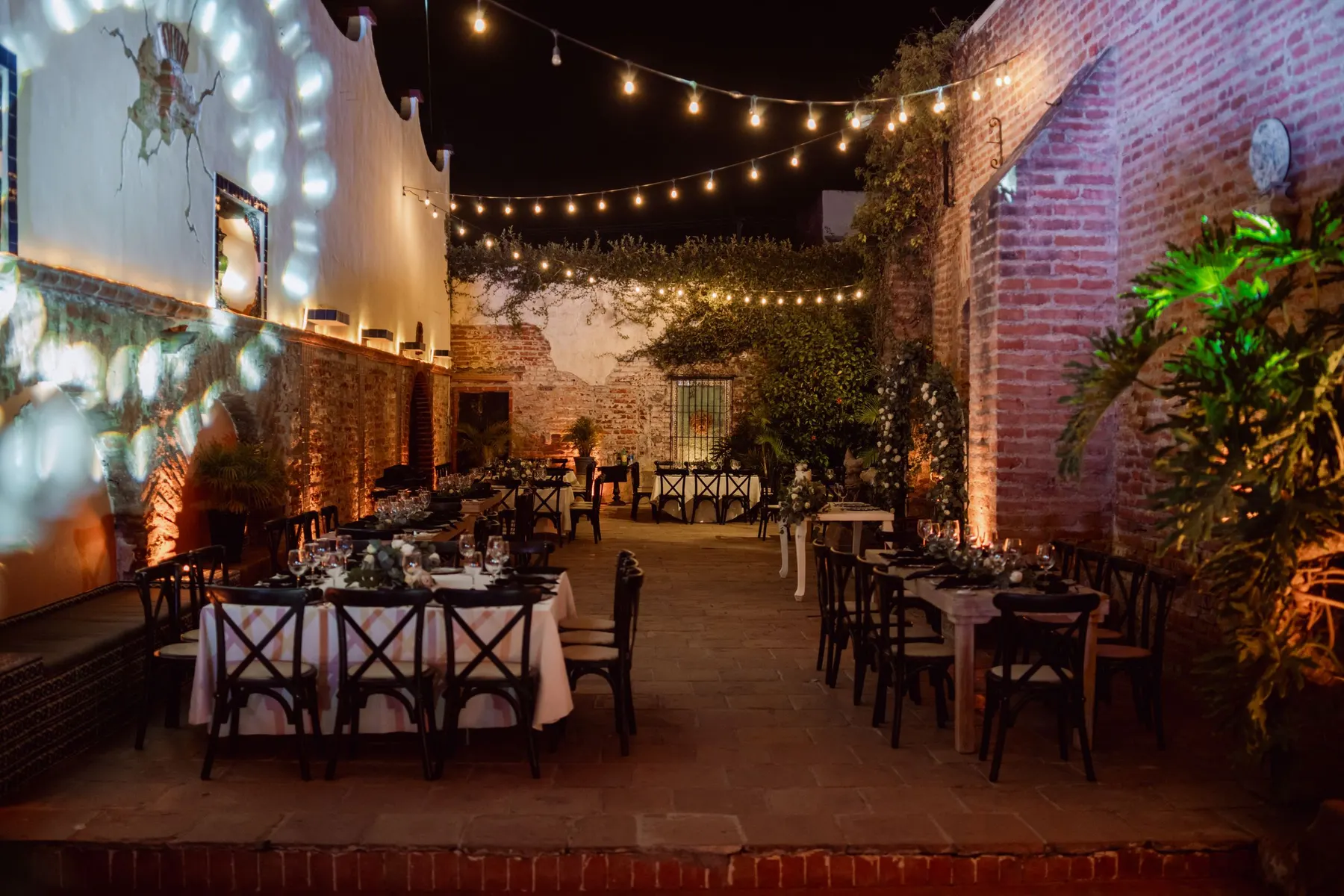 Outdoor evening tables set under strings of warm lights